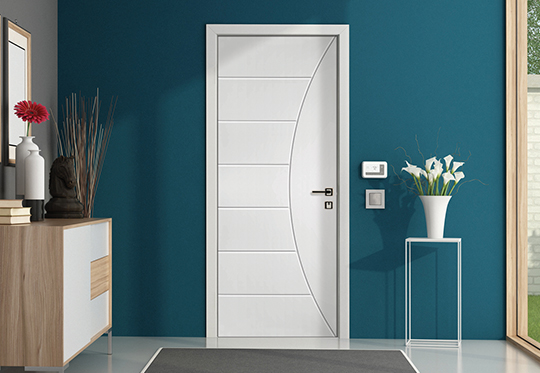 aqua blue wall with a white modern interior door next to a small table with white flowers