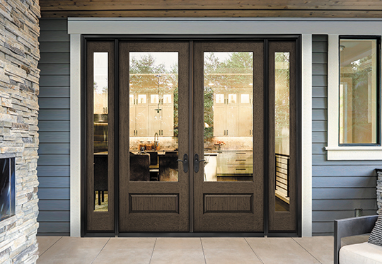 brown wood door with large clear glass panels on a sky blue house