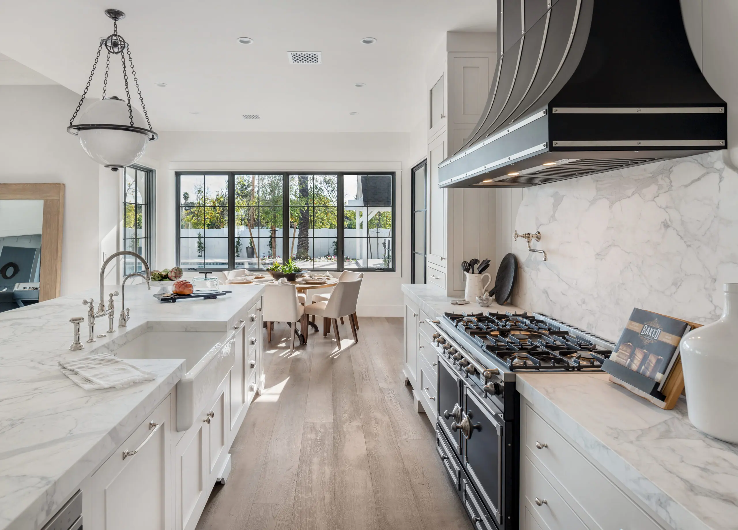 a white kitchen with white granite countertops and a gas stove