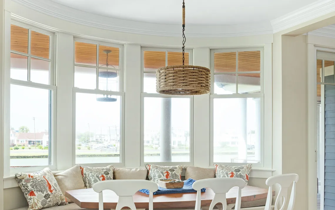 interior example showcase of andersen 400 series windows in a white living room with white chairs and a wooden table