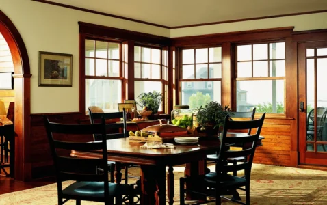rustic dining room with wood table and chairs in the center and andersen 400 series windows in the background