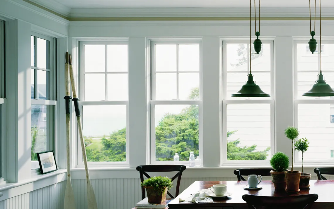 beach house dining room with andersen 400 series windows on a light green wall