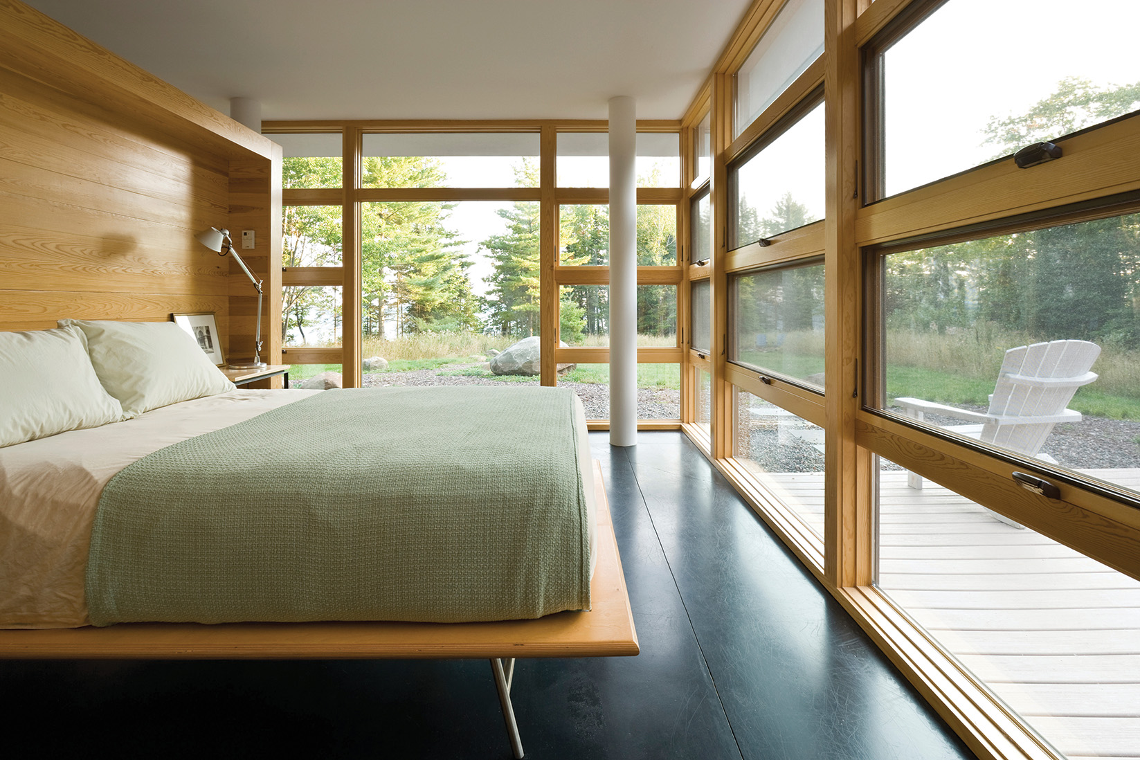 A bedroom with full awning window walls