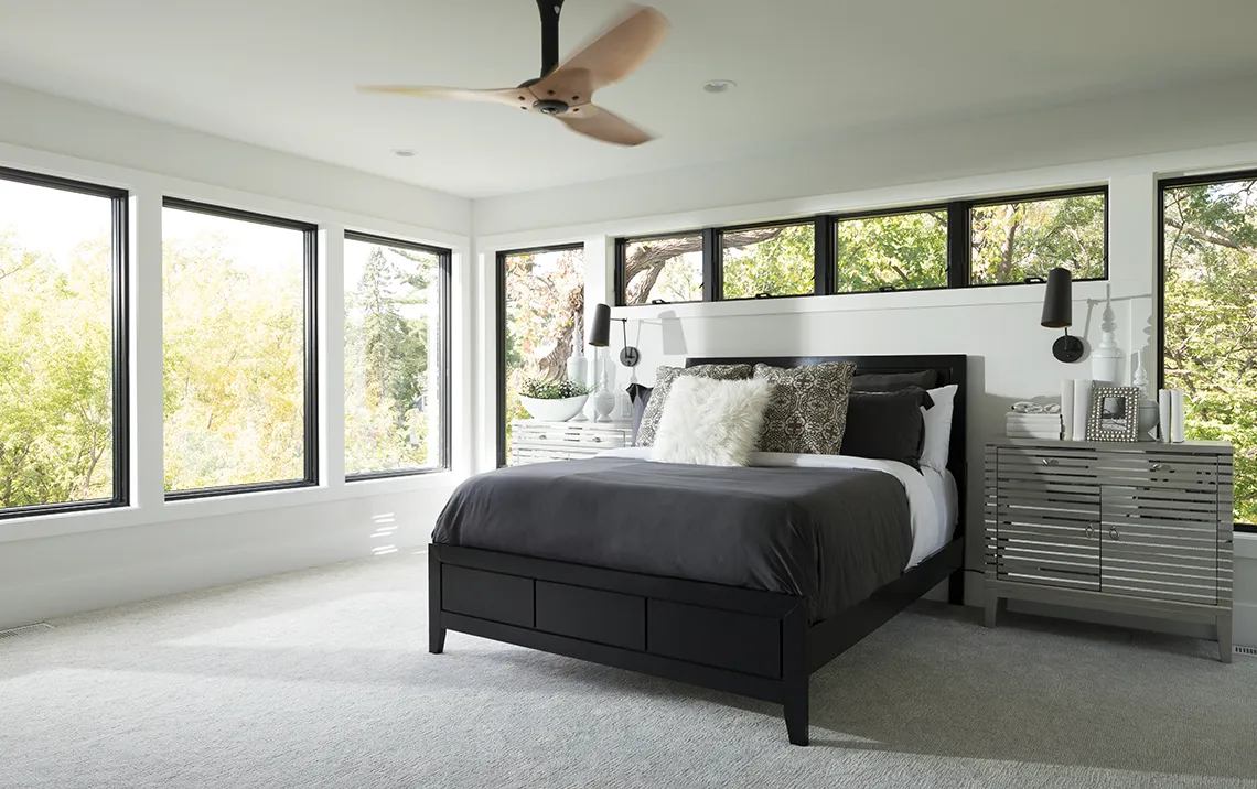 minimalist bedroom with open space and windows surrounding the walls and bed