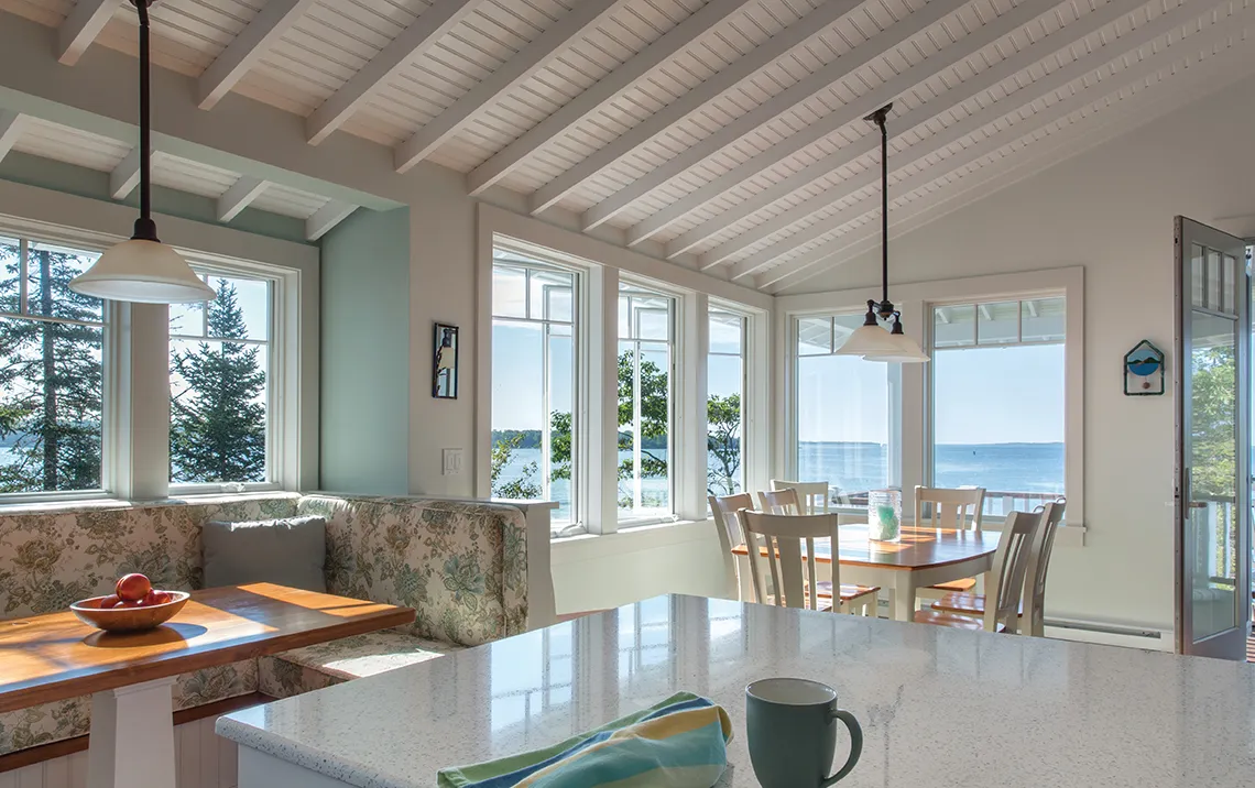 a beach house kitchen with a granite countertop and open windows