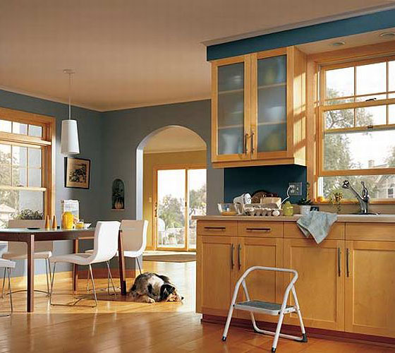 double hung windows inside a kitchen with a wooden floor and cabinets.