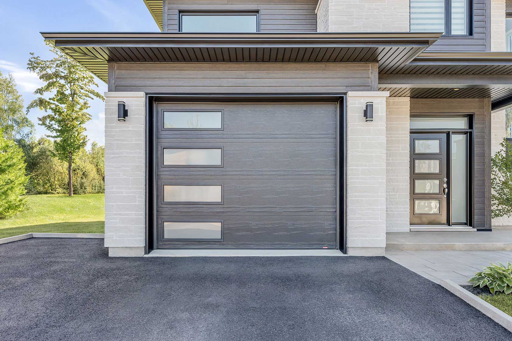brown garage door with a modern brown entry door installed on a modern house
