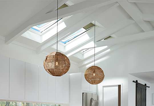 white ceiling with roof skylights and brown hanging light fixtures