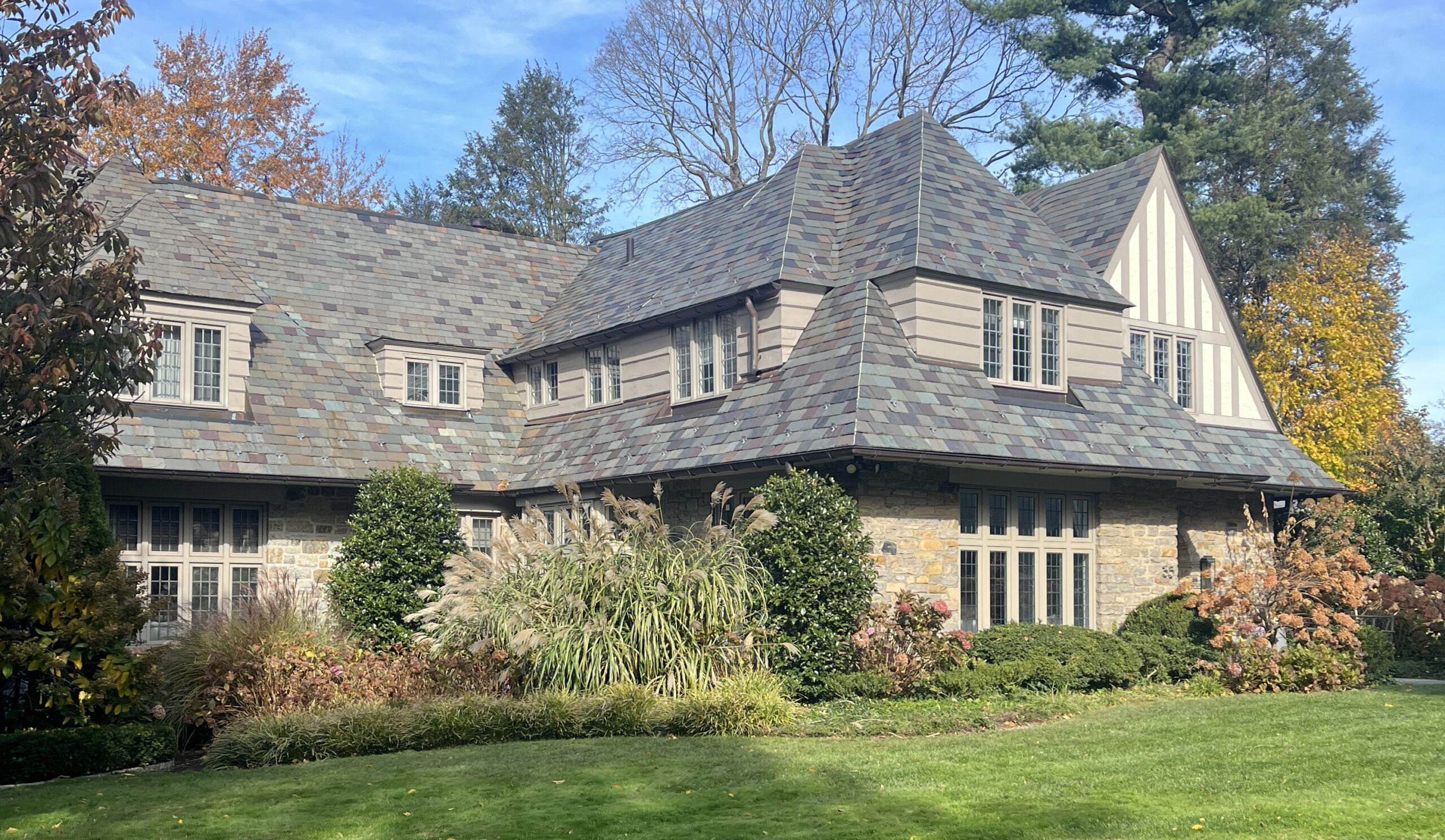 white brick home exterior with neatly trimmed lawn and large windows installed