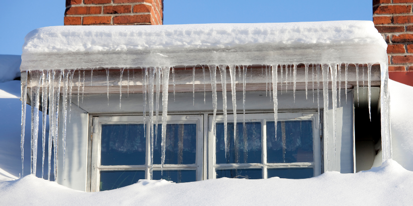 winter icicles frozen over a homes gutter